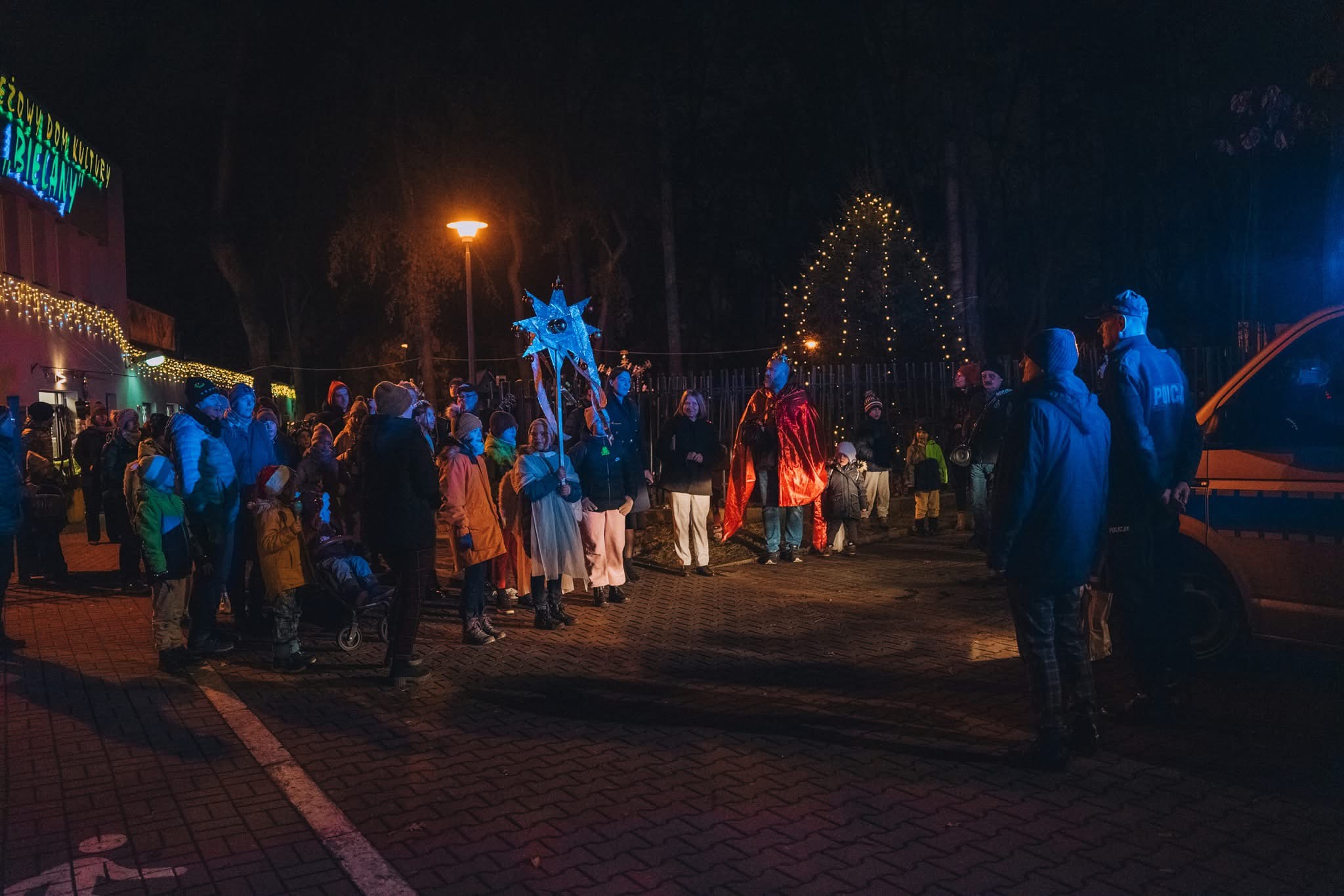 dzieci - kolędują z gwiazdą przed MDK Bielany, noc, policja na 1 planie